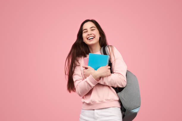 Delighted young student with copybooks smiling after exams stock photo
