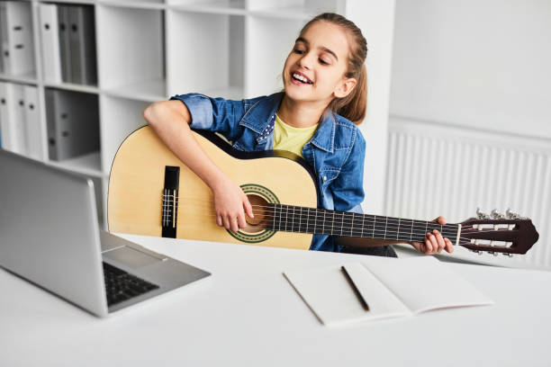istock Little guitarist during online lesson 1475808122