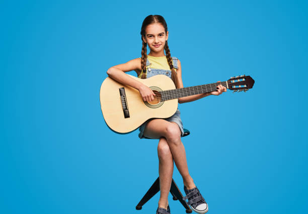istock Teen student playing guitar on stool 1475808139