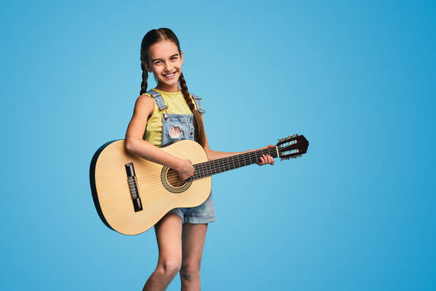 istock Merry girl playing guitar and smiling 1475808150