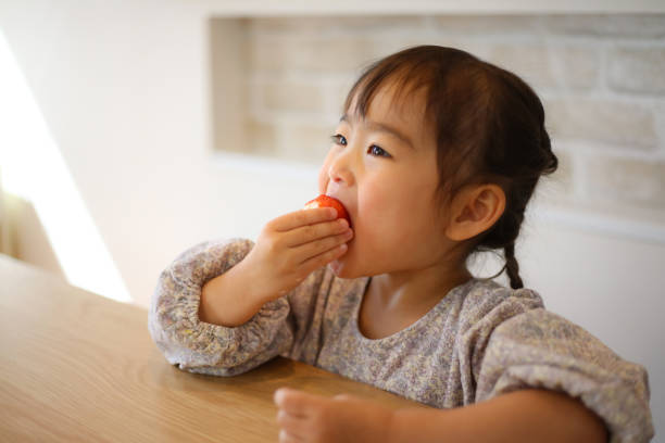 istock girl eating strawberry 1475810559