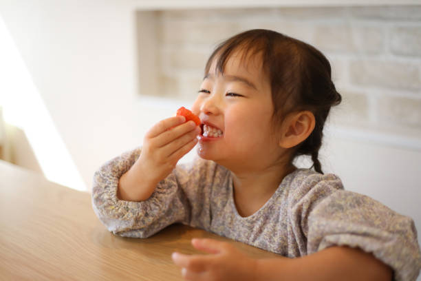 istock girl eating strawberry 1475810606