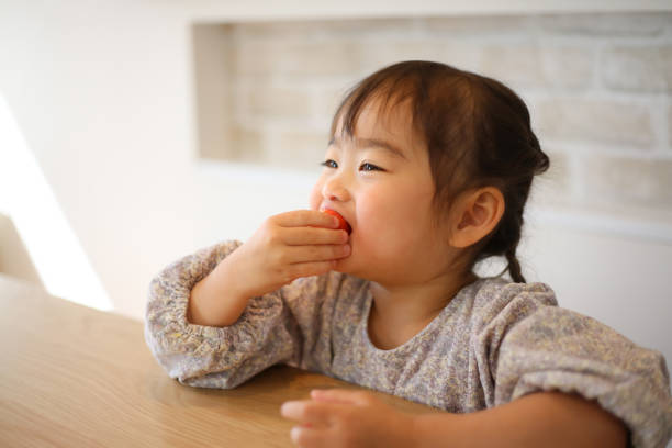 istock girl eating strawberry 1475810622