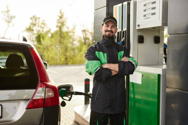 Positive gas station worker near car stock photo