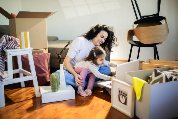 istock Woman and her little daughter using laptop while moving in 1475813519