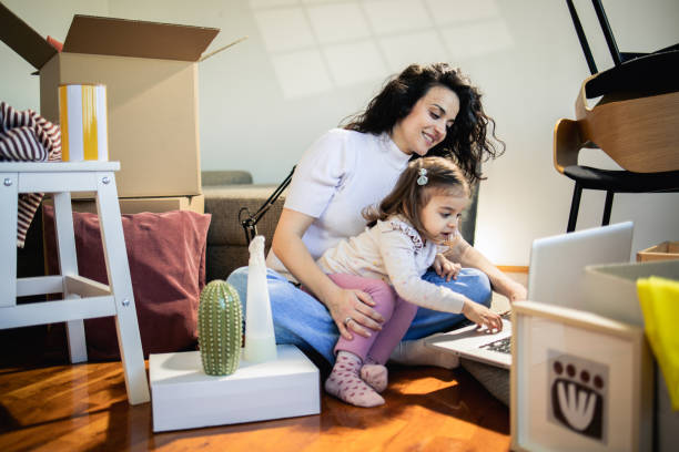 istock Cute girl and her mom using laptop while moving in 1475813521
