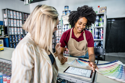 Saleswoman attending a customer at a paint store