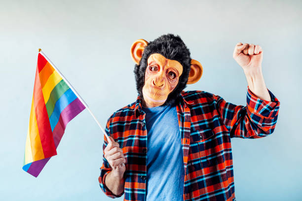 istock Man in monkey mask holding gay flag. 1475815661