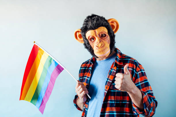 istock Man in monkey mask holding gay flag. 1475815701