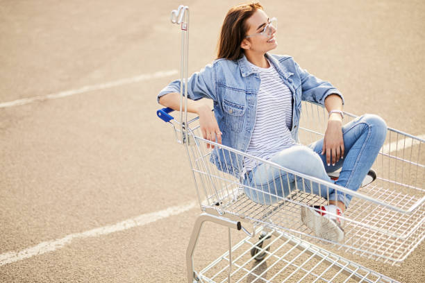 istock Relaxed female shopper sitting in trolley 1475819404