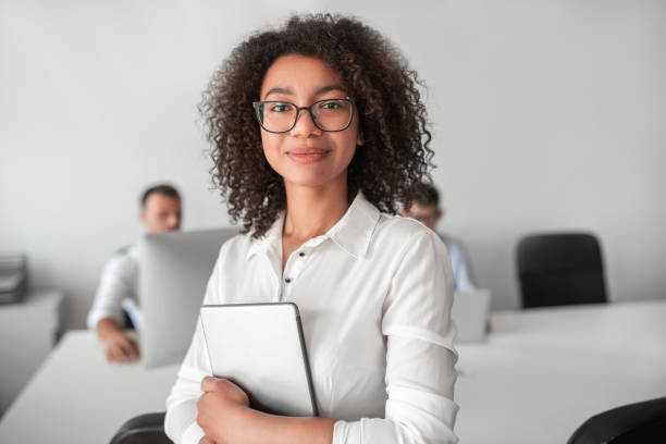 istock Smiling ethnic female recruiter with tablet looking at camera in office 1475823042