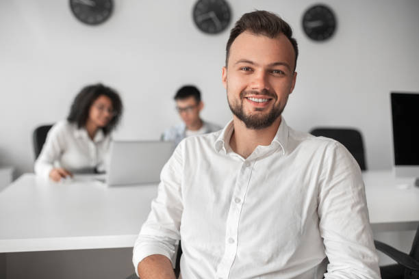 Bearded businessman near colleagues in office stock photo
