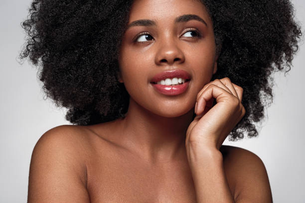 istock Smiling black lady with perfect skin looking away in studio 1475825150