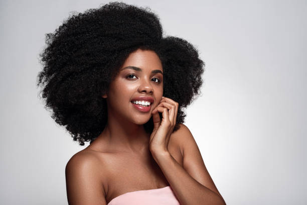 istock Positive African American lady touching cheek and smiling in studio 1475825200