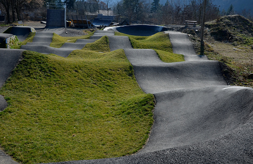 bike path in the car park Pumping (moving up and down) is used instead of pedaling and bouncing to move bicycles, scooters, skateboards and inline skates along the modular pumptrack track, picnic table