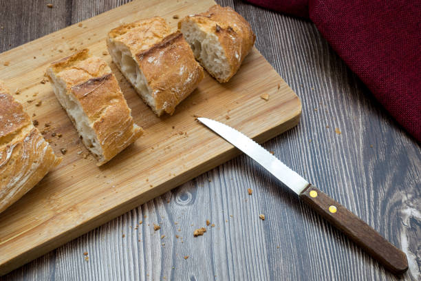 A loaf of fresh sliced bread on a cutting board and a knife