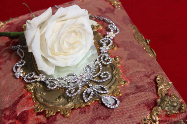 istock White Rose on Antique Book With Crystal Rhinestone Necklace 1475830125