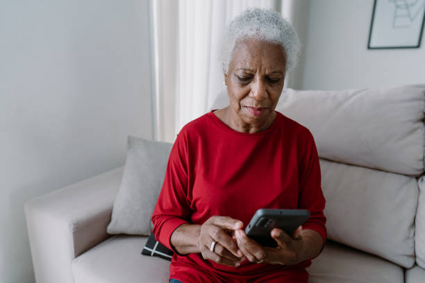 Portrait senior woman using smartphone at home Portrait senior woman using smartphone at home seria stock pictures, royalty-free photos & images