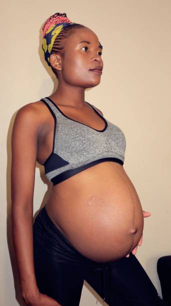 istock black woman holding her belly out 1475831625