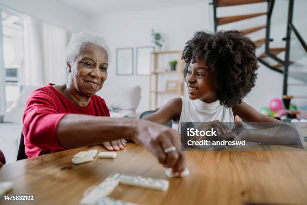 Grandmother Playing Dominoes With Her Granddaughter Stock Photo - Download Image Now