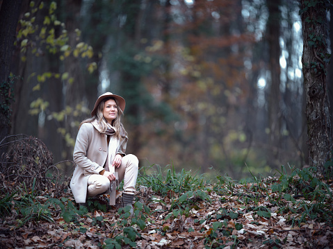 Young smiling woman day dreaming while spending her autumn day in nature. Copy space. Photographed in medium format.