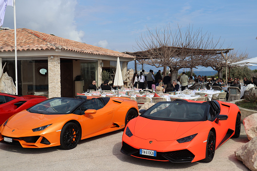 Cap D'Ail, France - 19.03.2023: View of luxury cars in Cap d'Ail near a small restaurant with an outdoor terrace