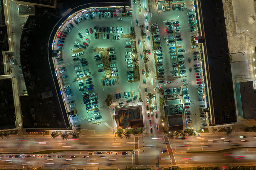 Aerial view of brightly illuminated street in downtown district of Miami city in Florida, USA. Traffic in modern american midtown.