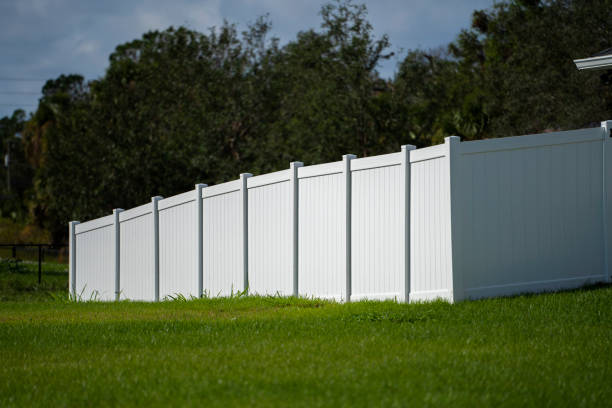 clôture de piquetage en vinyle blanc sur la pelouse verte entourant les terrains de la propriété pour la protection de la cour arrière et l’intimité - garden fence audio photos et images de collection
