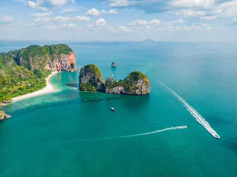 Woman tourist in yellow swimsuit and hat, happy traveller sunbathing at Maya Bay beach on Phi Phi island, Krabi, Thailand. landmark, destination Southeast Asia Travel, vacation and holiday concept