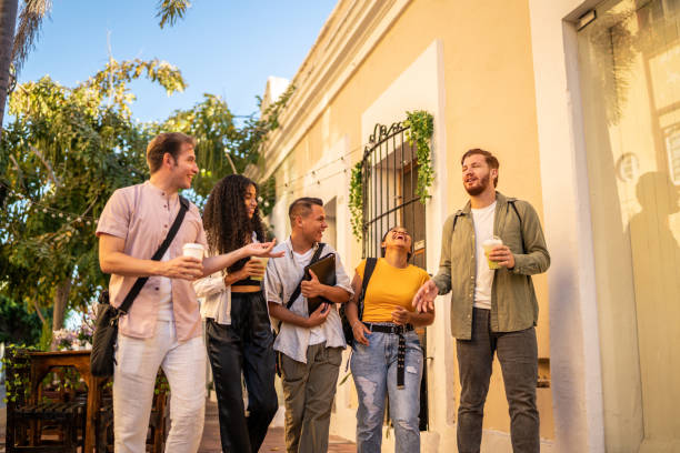 istock Happy young friends talking while walking on the street 1475838597