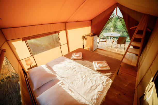 istock Interior of Cozy open glamping tent with light inside during sunset. Luxury camping tent for outdoor summer holiday and vacation. Lifestyle concept 1475840665