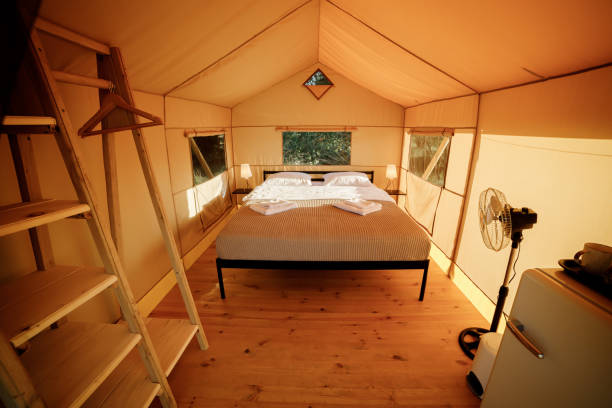 istock Interior of Cozy open glamping tent with light inside during sunset. Luxury camping tent for outdoor summer holiday and vacation. Lifestyle concept 1475840964