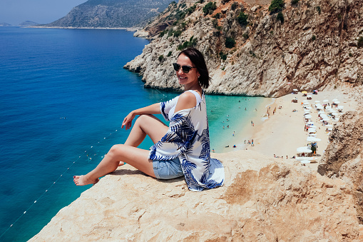 Woman sunbathing at sandy beach. Mediterranean sea.
