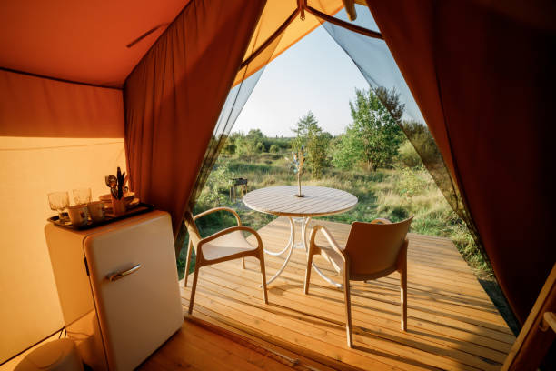istock Interior of Cozy open glamping tent with light inside during sunset. Luxury camping tent for outdoor summer holiday and vacation. Lifestyle concept 1475841254