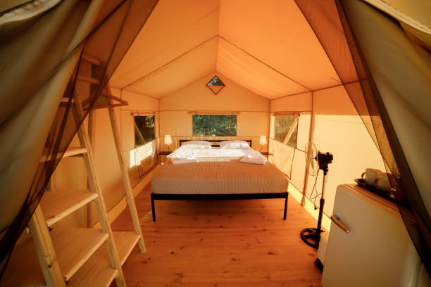 istock Interior of Cozy open glamping tent with light inside during sunset. Luxury camping tent for outdoor summer holiday and vacation. Lifestyle concept 1475841895