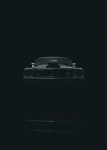 Beaconsfield, UK - March 24, 2023: A scale model of 1968 Ford Mustang, a genuine icon of the 1960's, sitting on a reflective black surface against a black background.
