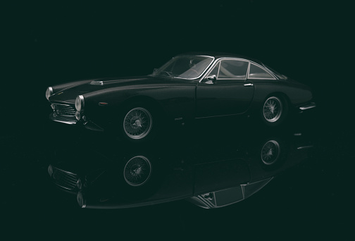 Beaconsfield, UK - March 24, 2023: A glorious scale model of the beautiful 1963 Ferrari 250 GT Berlinetta Lusso sitting on a reflective black base against a black background.