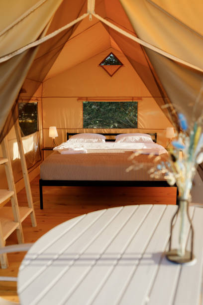 istock Interior of Cozy open glamping tent with light inside during sunset. Luxury camping tent for outdoor summer holiday and vacation. Lifestyle concept 1475842778