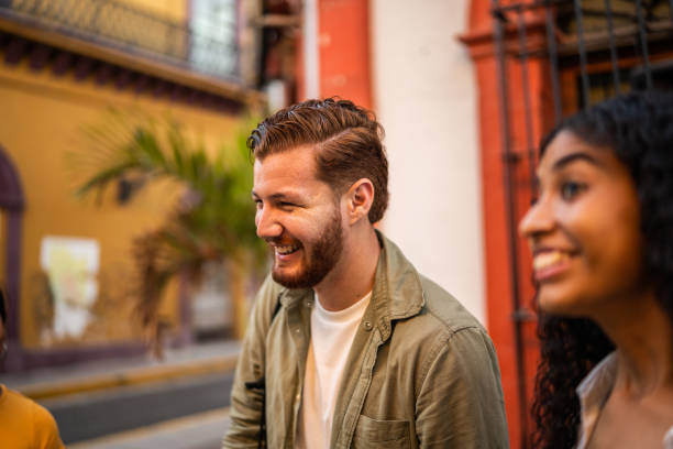 istock Young man having fun while talking with his friends on the street 1475845000