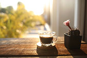 istock coffee glass cup and pink cactus flower in a pot on wooden table with natural sunshine 1475849284