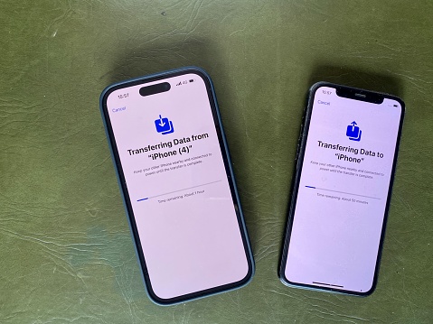 Cape Town, South Africa - March 24, 2023:  Setting up new iPhone 14 Pro in Space Black with older iPhone 11 Pro, transferring Data