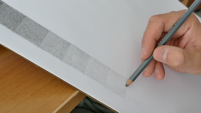 Shades of Gray Squares with Pencil on a White Paper