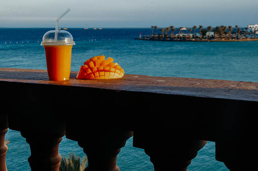 Fresh sliced mango fruit and freshly squeezed mango juice on the balcony with beautiful Red sea view
