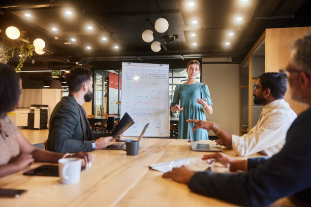 istock Young businesswoman talking to colleagues while doing a presentation on a whiteboard 1475861624