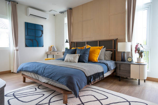 cuscino giallo e blu in camera da letto moderna con moquette e lampada da tavolo. - window cushion old built structure foto e immagini stock