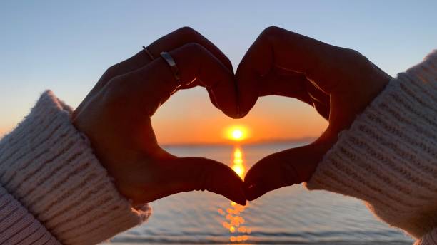 istock hands forming a heart shape with sunrise silhouette 1475866839