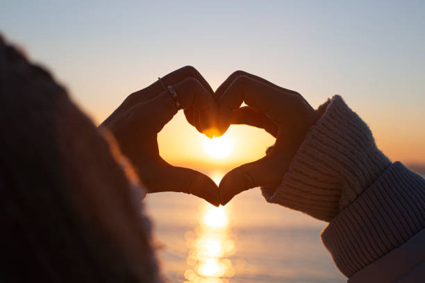 istock hands forming a heart shape with sunrise silhouette 1475867373