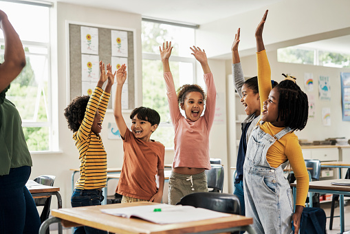 Kids, fun stretching and classroom hands in the air for happy children assessment growth in a school. Students, exercise and happiness of young group in a education study hall with student motivation