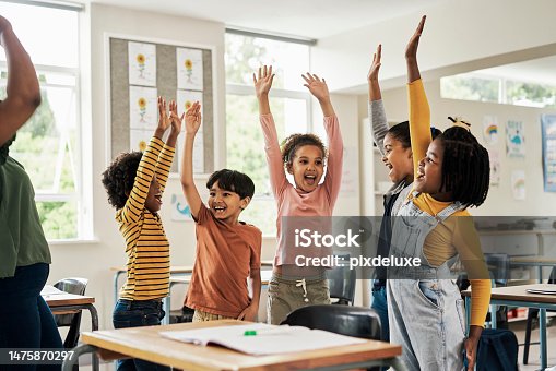 istock Kids, fun stretching and classroom hands in the air for happy children assessment growth in a school. Students, exercise and happiness of young group in a education study hall with student motivation 1475870297