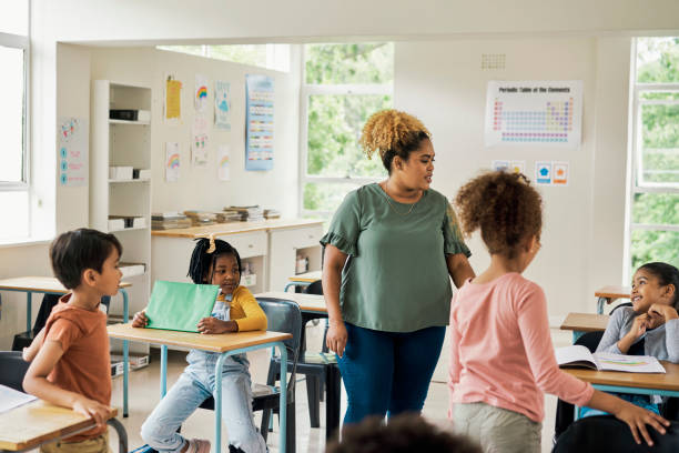 istock Education, learning and teacher with children in classroom for knowledge, project and assignment. Study, child development and school with black woman and students for solution, teaching and youth 1475870473
